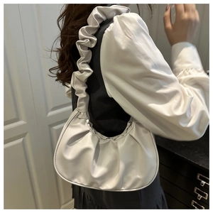 Detail of a beige pleated shoulder bag with matte PU texture on a model shoulder
