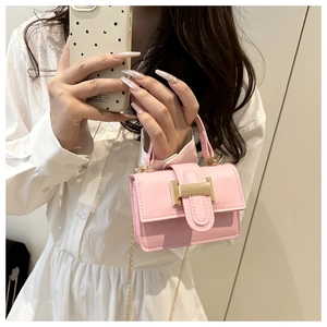 Vue détaillée d'un mini sac à main rose avec bandoulière dorée et cuir à texture fine