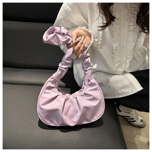 Detail of lavender pleated crescent bag featuring soft ruffled handle and premium texture