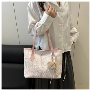 Detail of Korean tote bag with pink straps and brown plush bear charm accessory