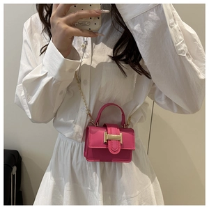 Détail du mini sac carré rose fuchsia avec boucle dorée et bandoulière chaîne