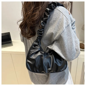 Detailed view of the pleated black cloud bag with textured shoulder strap and soft PU leather
