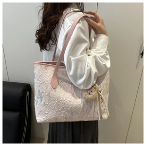 Detail der creme Jacquard-Einkaufstasche mit rosa Riemen und süßem Teddybär-Anhänger