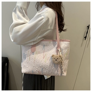 Rosafarbene strukturierte Tragetasche mit Stickerei und einem Teddybär-Anhänger