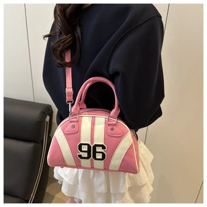 Detailopname van roze en witte bowlingtas met nummer 96 patch gedragen als crossbody