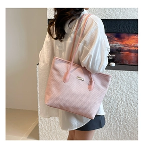 Détail du sac cabas rose avec logo métallique rectangulaire et texture structurée