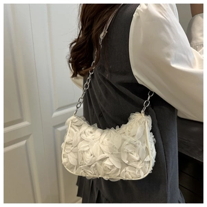 Detailansicht weißer 3D-Blütenblätter und Silberkette dieser eleganten Abendtasche