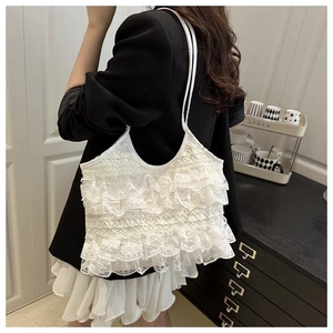 Close-up of white lace ruffle shoulder bag with layered floral mesh and long handles