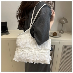 Detailed close-up of white layered lace tote bag with delicate ruffle edges and thin straps