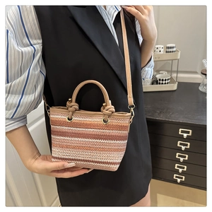 Close-up of the tri-color woven stripes and leather handles of the summer tote bag