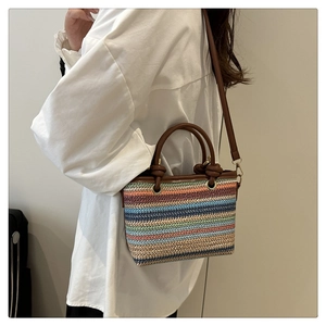 Mannequin portant un sac cabas en paille à rayures colorées et poignées nouées