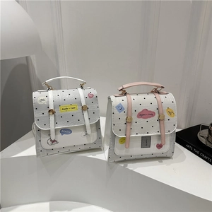 Minimalist polka dot PU crossbody bag with lace trim and cute cartoon stickers on white stand