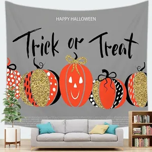 Detalle de tapiz de Halloween con calabazas Trick or Treat sobre una pared gris