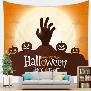 Detalle de tapiz de Halloween con mano de zombi y calabazas sobre un sofá gris
