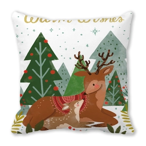Dettaglio copricuscino natalizio con renne, albero e testo dorato Warm Wishes