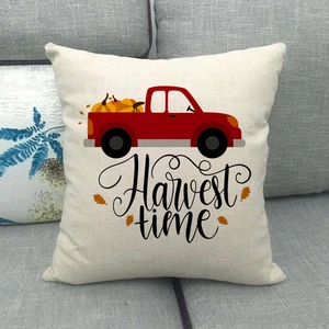 Dettaglio del copricuscino con camion rosso e zucche stampate su tessuto in lino beige