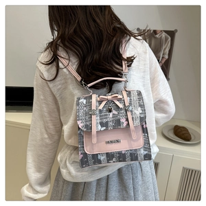 Detail of pink PU leather backpack with butterfly print fabric and heart pendant