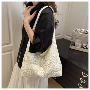 Gros plan détaillé de la texture en dentelle florale sur le grand sac cabas blanc
