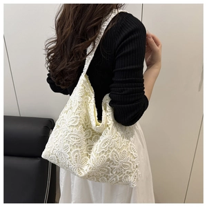 Détail de la texture en dentelle florale d'un grand sac cabas blanc avec doublure douce