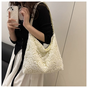 Détail du sac cabas en dentelle blanche avec broderie florale 3D et design hobo spacieux