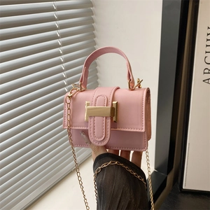 Mini sac à main rose vintage avec poignée et chaîne dorée dans un intérieur minimaliste