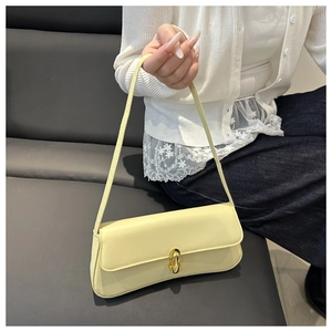 Dettaglio della borsa baguette giallo crema con un’elegante chiusura in metallo dorato