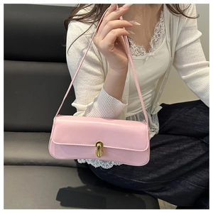 Elegante borsa baguette in pelle rosa con fibbia dorata abbinata a un cardigan di pizzo
