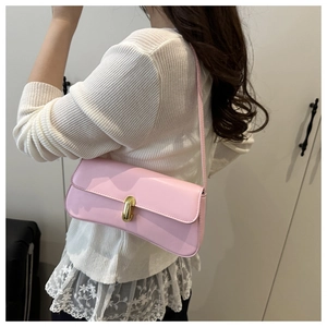 Detail of light pink shoulder bag with gold twist lock on glossy leather