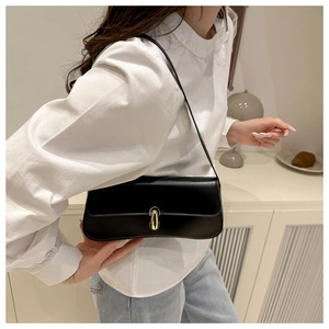 Dettaglio di una borsa sottobraccio nera con elegante fibbia cilindrica in metallo oro