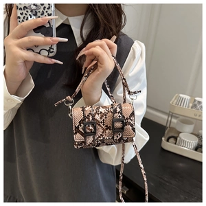 Dettaglio mini borsa a motivo pitonato con fibbie nere e tracolla sottile