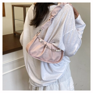 Detail of pink pleated satin handbag with elegant pearl and flower decorative chain