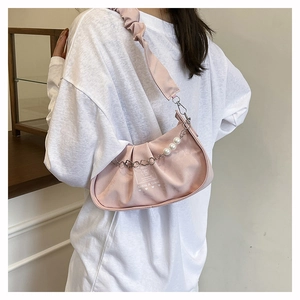 Detail of pink hobo bag with pleated texture, pearl chain charm and brand lettering
