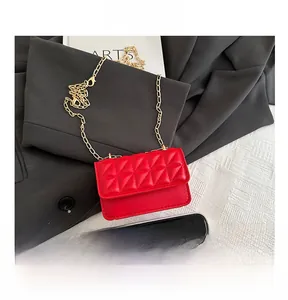 Detailed view of red quilted chain bag with smartphone to show mini size and texture