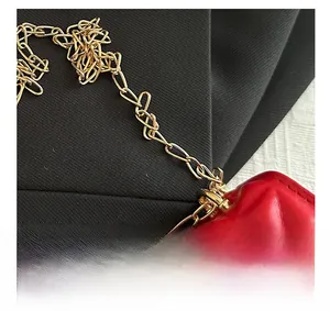 Detail of a red quilted leather bag featuring a gold chain strap and polished hardware