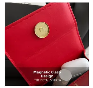 Detail of red lychee leather bag showing magnetic closure for earphones and lipstick