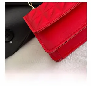 Detail view of precise stitching on a red quilted faux leather crossbody square bag