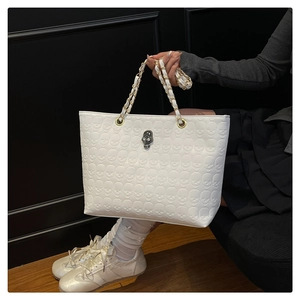 Détail du sac cabas blanc avec textures tête de mort en relief et ornement en cristal