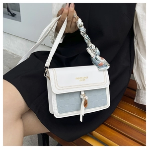 Detail of cream crossbody bag with checkerboard texture and silk scarf handle