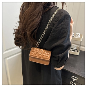 Brown quilted mini square bag with gold chain strap shown on a woman for daily wear
