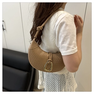 Detail of camel woven texture hobo bag with gold horseshoe buckle and knotted shoulder strap