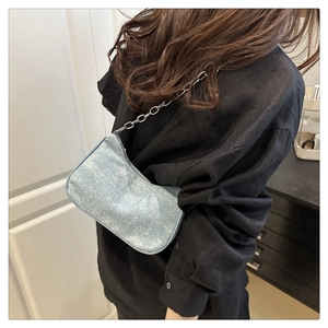 Détail du sac sous le bras bleu clair scintillant avec chaîne argentée par un mannequin