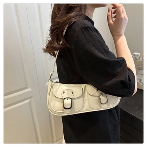 Detail of cream baguette shoulder bag with twin retro buckles and high-gloss finish