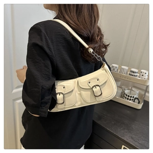 Detailed back view of model wearing a cream leather baguette bag with dual cargo pockets