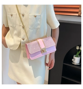 Detail of pink glitter flap bag with golden twist lock and elegant metal chain strap