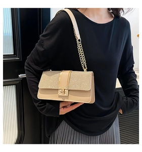 Detail of elegant champagne small square bag with glitter flap and chain strap