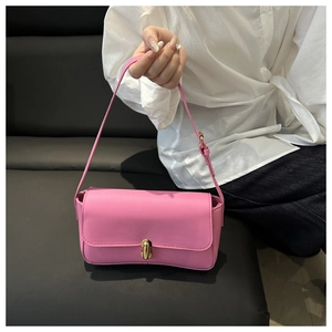 Detailed view of pink faux leather baguette bag with elegant golden twist-lock closure