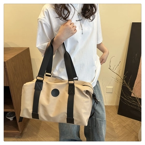 Detail of waterproof beige Oxford gym bag featuring black nylon straps and shoulder carry