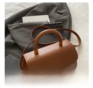 Detail of vintage gold circular lock and brown faux leather texture on the bag