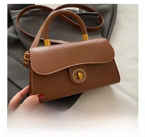 Close-up of vintage brown leather bag featuring a premium gold-toned circular metal lock