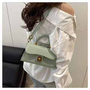 Detail of mint green leather crossbody bag with vintage gold lock on model